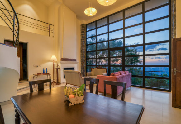 Lounge seating area with large windows and natural light — Mangohills Hotel, Yercaud